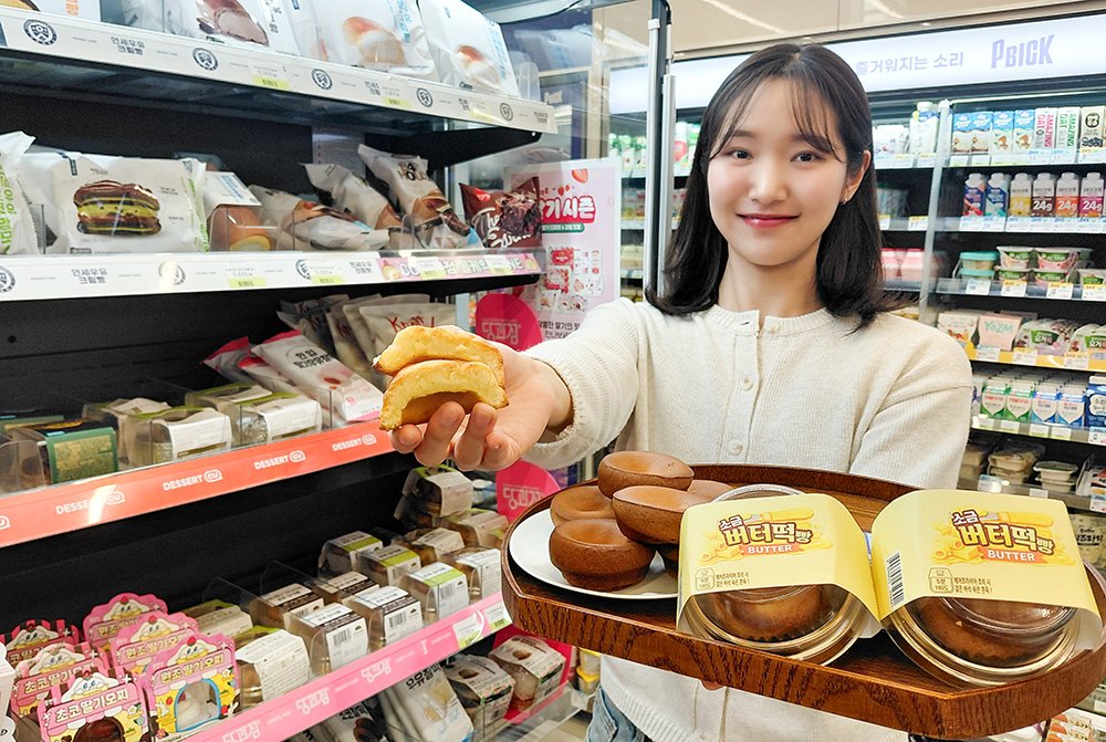 CU convenience store butter tteok launch in Korea — golden baked rice cakes on a tray